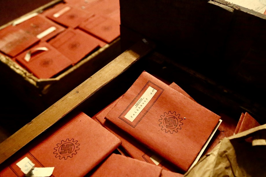 Libretas de afiliación con símbolos nazis encontradas dentro de las cajas.